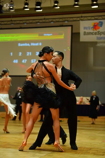 Dancesport competitor: Main female dancer: black Latin dance dress with a feathered skirt and sequin em