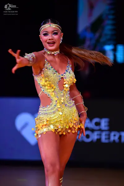 Dancesport competitor: Female dancer: yellow latin dress covered in sequins and large paillettes with s