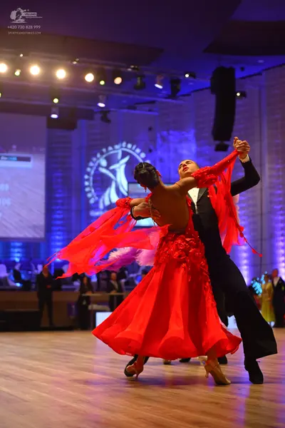 Dancesport competitor: Female dancer: red ballroom dress with floral lace details on the bodice and a f