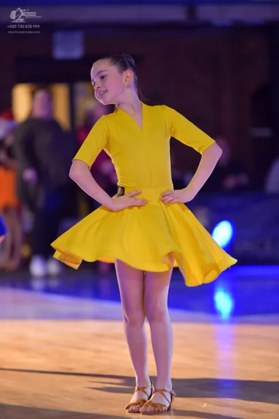 Dancesport competitor: Female dancer: yellow short-sleeved latin dress with a flared skirt