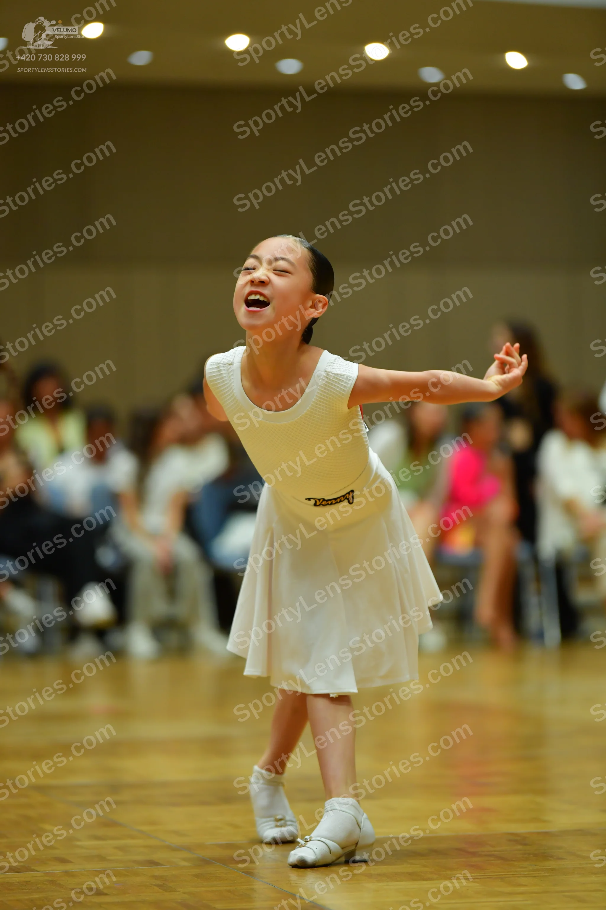 Dancesport competitor: Female dancer: white sleeveless dress with a textured top and a flared skirt
