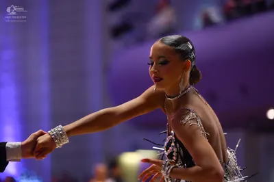 Dancesport competitor: Female dancer: black Latin dress decorated with silver sequins and rhinestones