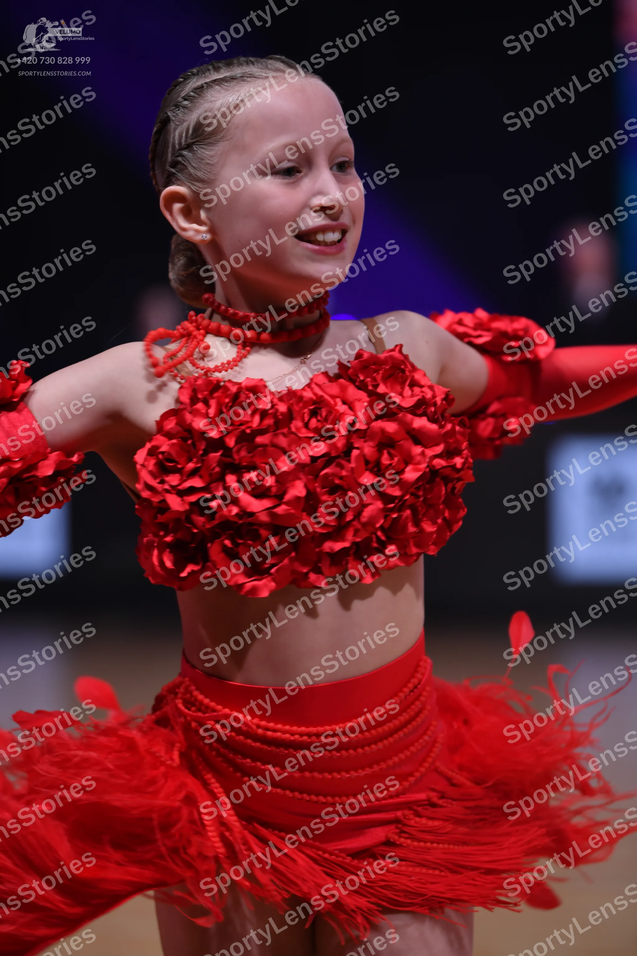 Dancesport competitor: Female dancer: red latin dress with 3D floral rose top, long sleeves, and feathe