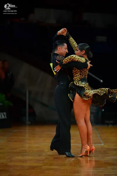 Dancesport competitor: Male dancer: black long-sleeved shirt with black lace or mesh detailing on the s