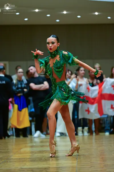 Dancesport competitor: Female dancer: bright green Latin dress with sequins and fringe