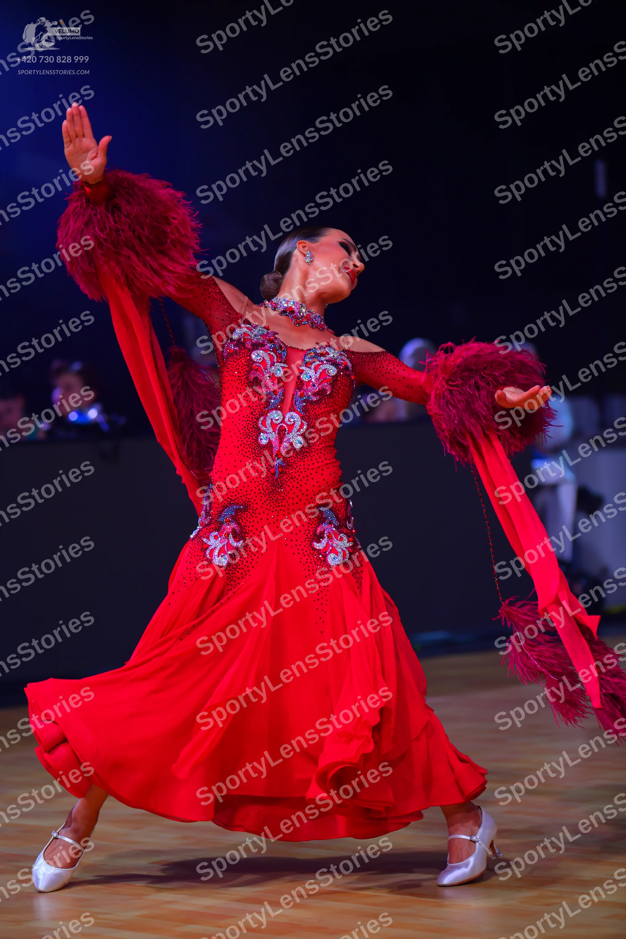 Dancesport competitor: Female dancer: red long flowing dress with silver, blue, and white sequin/beadwo