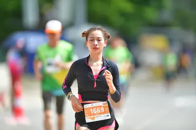 Marathon runner #1669: Runner 1: black long-sleeved top with pink trim, black shorts with pink trim, ye