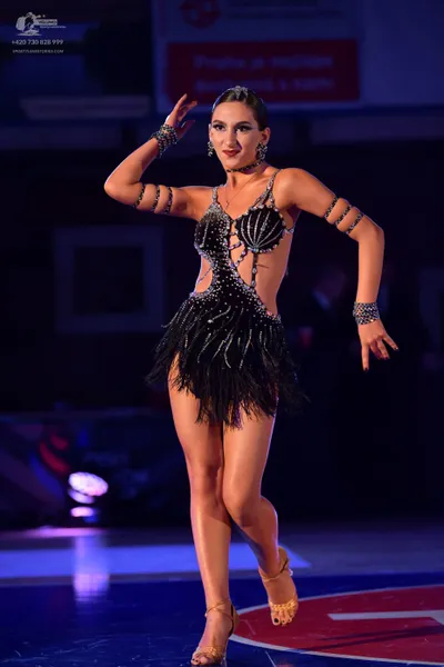 Dancesport competitor: Female dancer: black latin dress with heavy silver rhinestone embellishments, a 