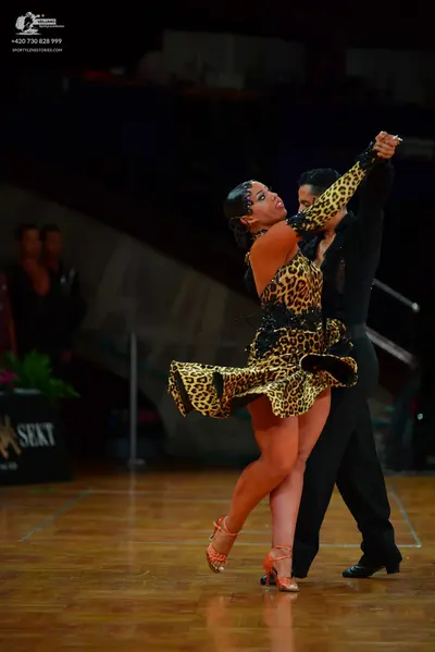 Dancesport competitor: Female dancer: leopard print Latin dress with black sequin/bead details and tan 