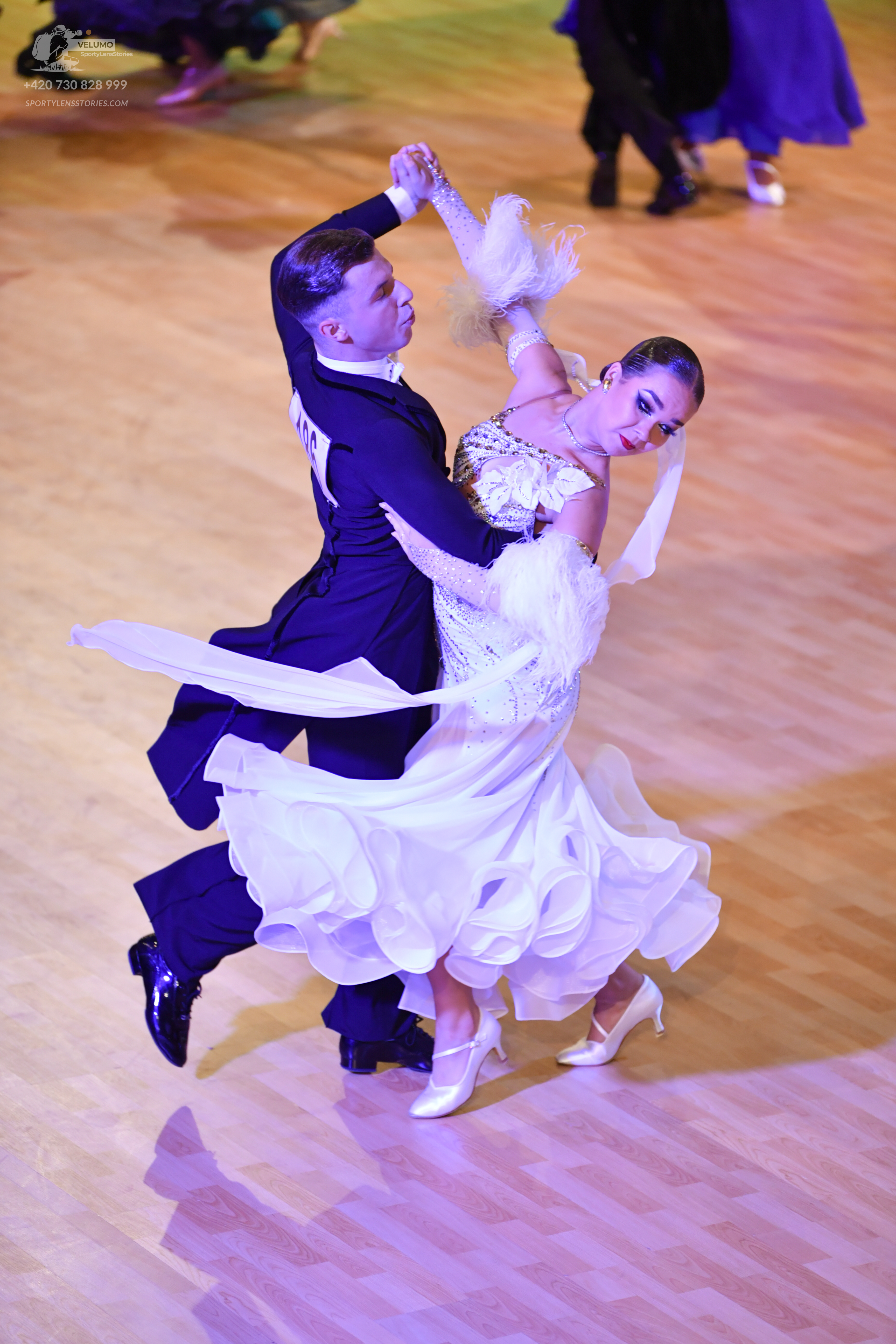Dancesport competitor: Male:** Black tail suit with silver sequin detailing on the lapels and sleeves
