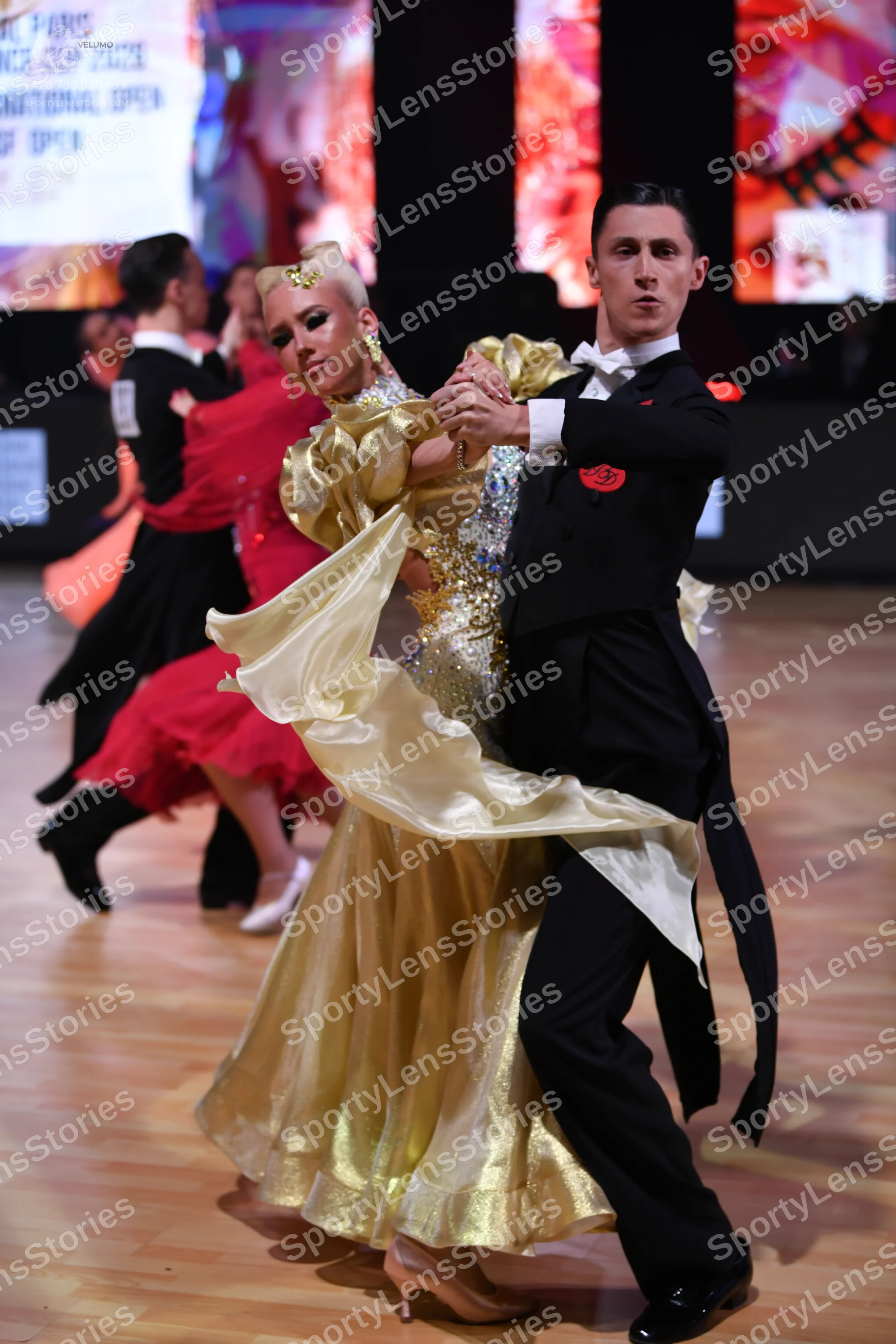 Dancesport competitor: Male dancer: black tailcoat with a white shirt, white bow tie, and a red floral
