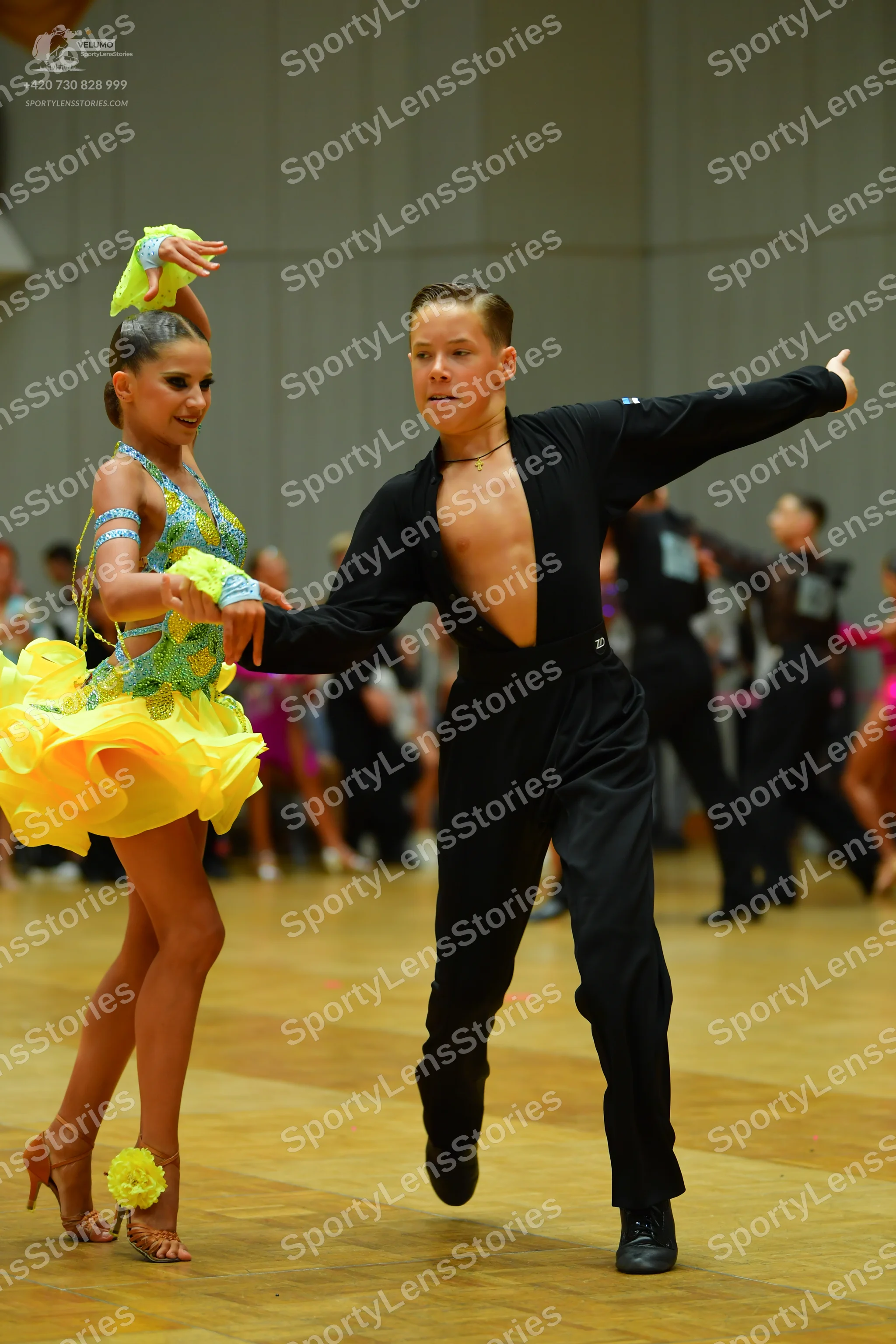 Dancesport competitor: Female dancer: yellow and light blue latin dress with a ruffled yellow skirt and