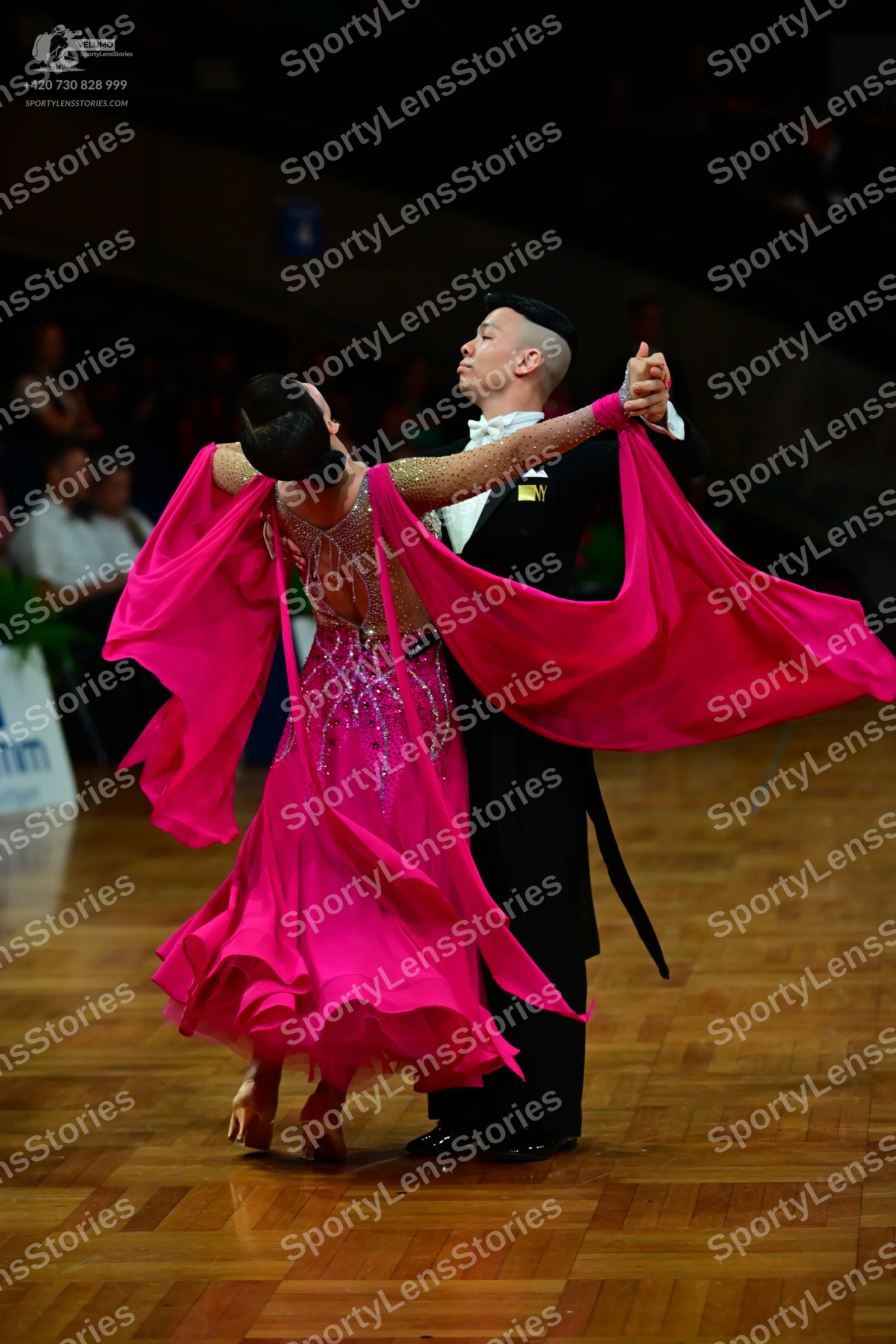 Dancesport competitor: Female dancer: bright pink latin dress with a sheer, embellished bodice and long