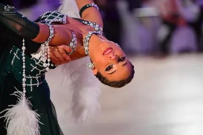 Dancesport competitor: Female dancer: emerald green Latin dance dress with white and silver sequin or p