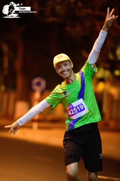 Marathon runner #42519: Runner 1: green jersey with blue stripe, white long-sleeved undershirt, black sh