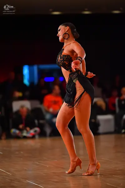 Dancesport competitor #310: Female dancer: black lace Latin dress with a fringe skirt, large hoop earrings, 