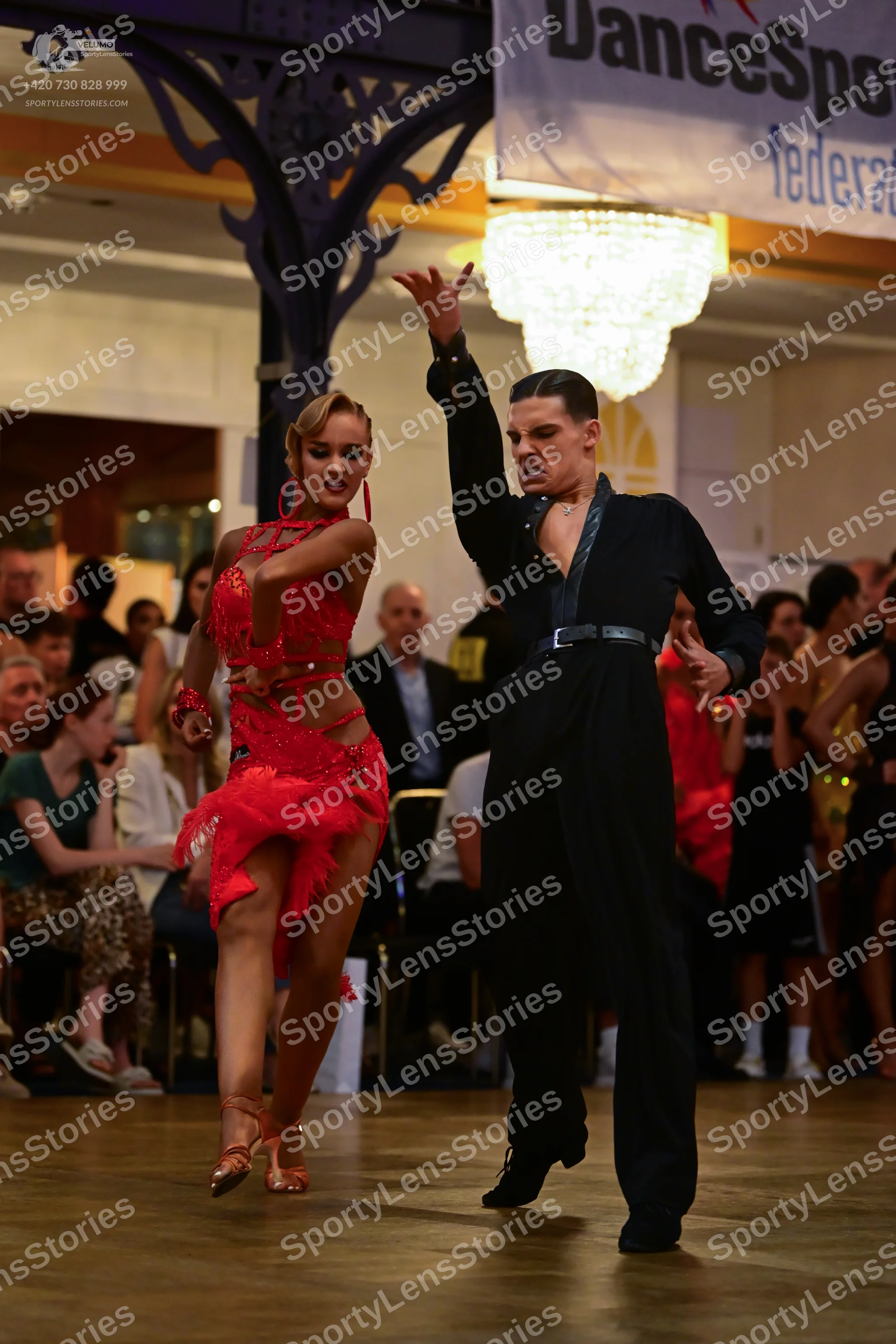 Dancesport competitor: Female dancer: red latin dress embellished with red sequins and rhinestones, fea