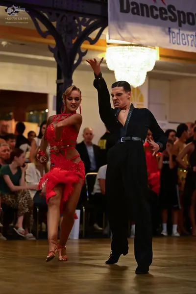 Dancesport competitor: Female dancer: red latin dress embellished with red sequins and rhinestones, fea