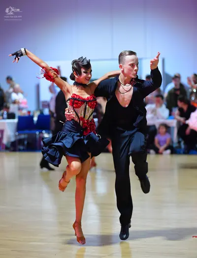 Dancesport competitor: Male dancer: black long-sleeved shirt, partially unbuttoned, black trousers, and