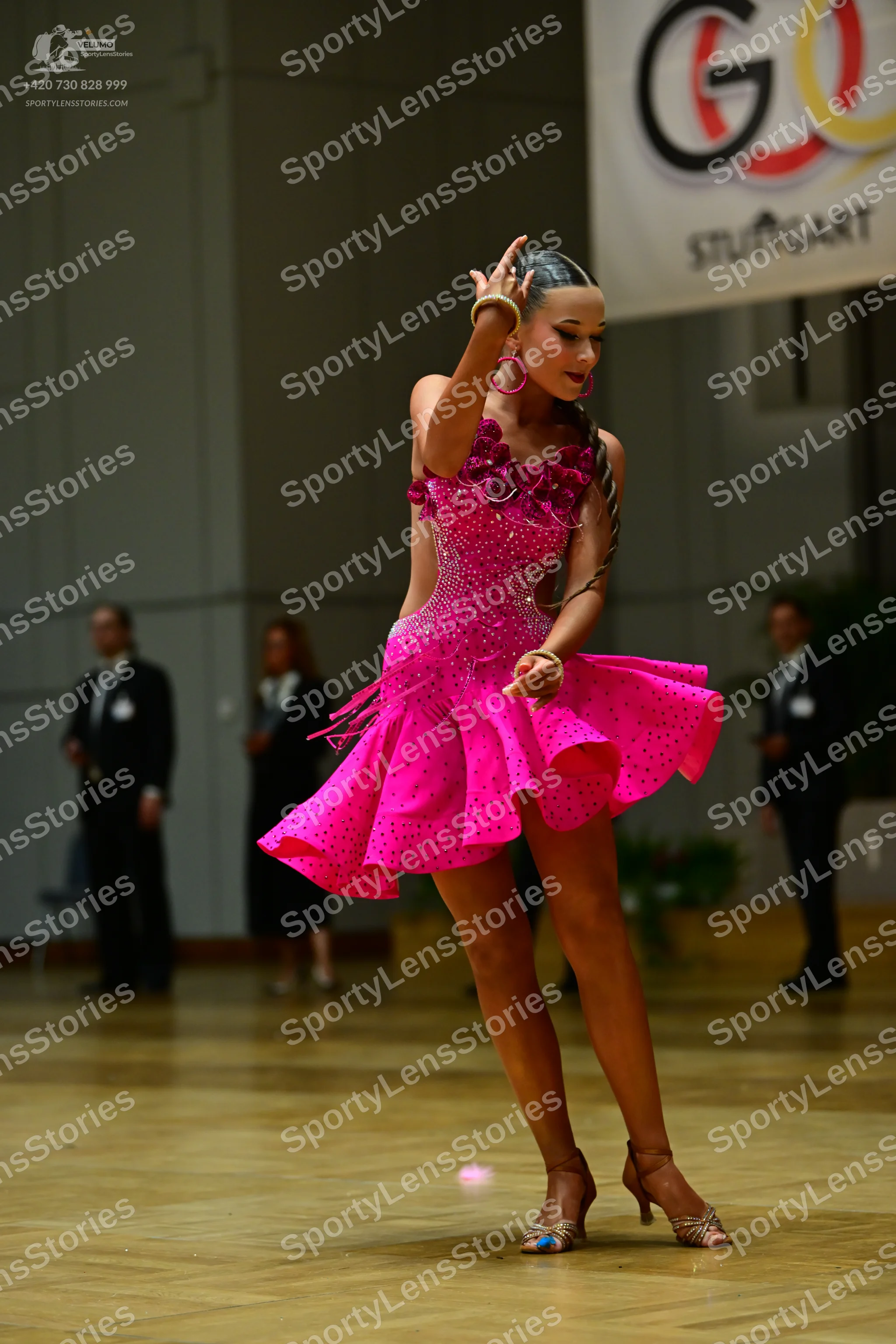 Dancesport competitor: Female dancer: bright pink Latin dance dress with rhinestone embellishments and 