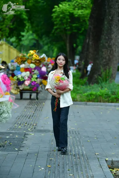 Dancesport competitor: Female dancer: cream-colored long-sleeved shirt and dark trousers