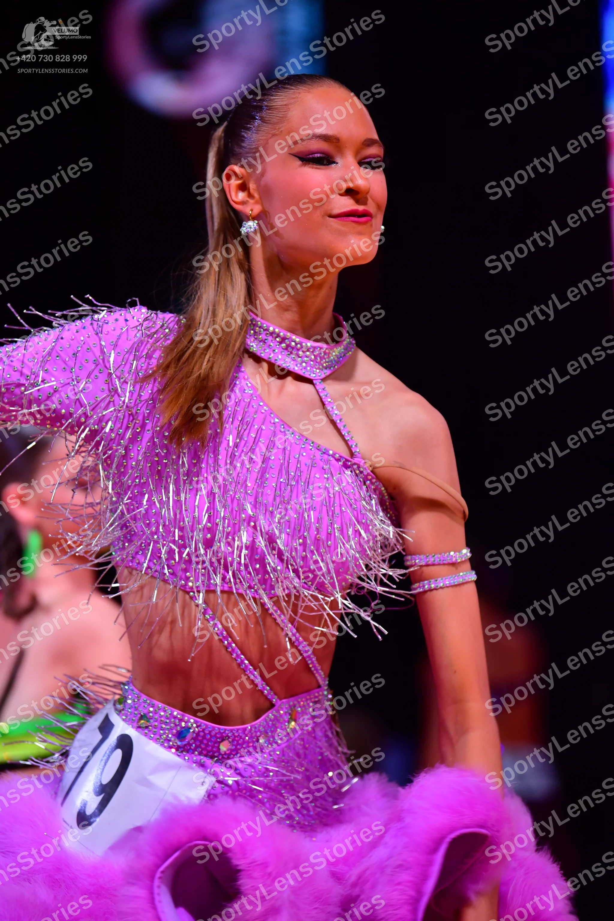 Dancesport competitor: Female dancer: bright pink Latin dance costume with sequins, long sparkly fringe