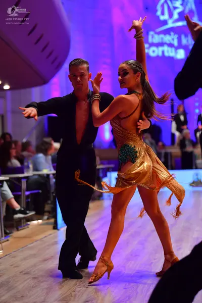 Dancesport competitor: Male dancer: black long-sleeved shirt, open at the chest, and black trousers