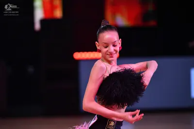 Dancesport competitor: Female dancer: black top with large black feathery texture, black bottoms with l