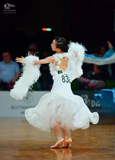 Dancesport competitor: Female dancer: white ballroom dress with lace detailing and large white feathery
