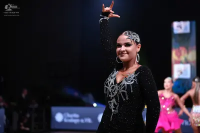 Dancesport competitor: Main female dancer: black long-sleeved dress with silver sequin/beadwork pattern