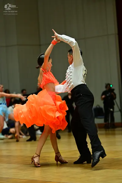 Dancesport competitor: Male dancer: white long-sleeved shirt with ruffles and black trousers