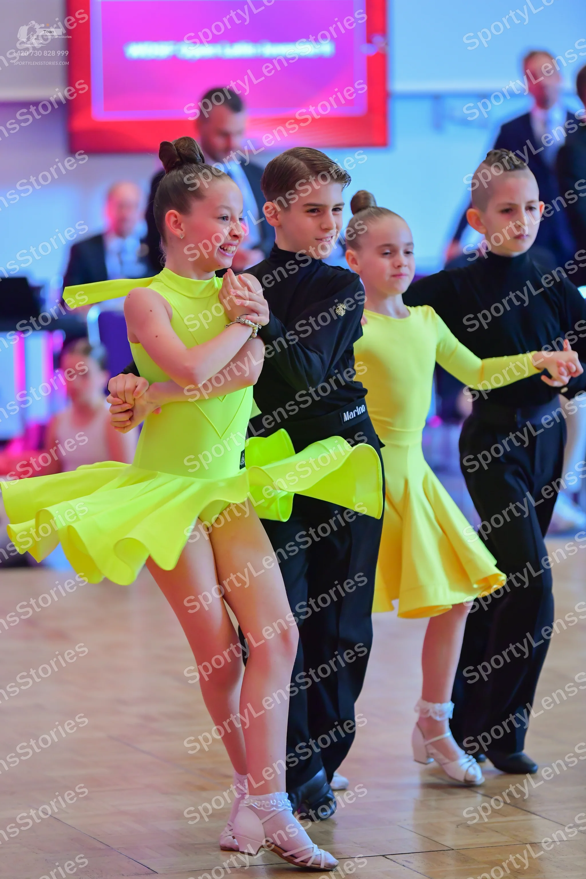 Dancesport competitor: Female dancer 1: lime green latin dress with a ruffled skirt and long sleeves