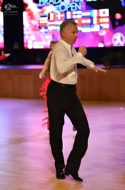 Dancesport competitor: Male dancer: white long-sleeved textured shirt and black trousers