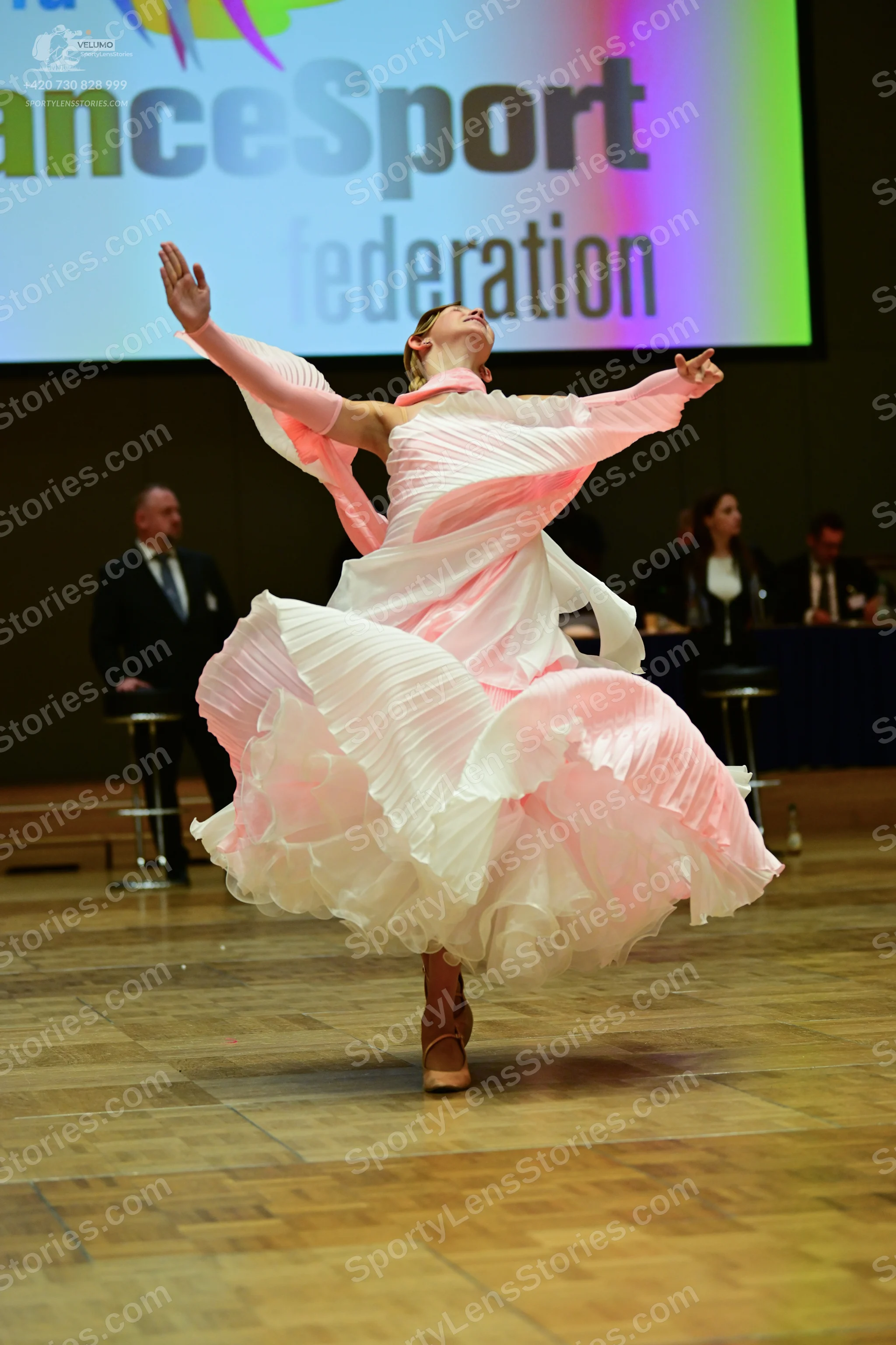 Dancesport competitor: ** She's wearing a pale pink (almost white) voluminous ballroom gown