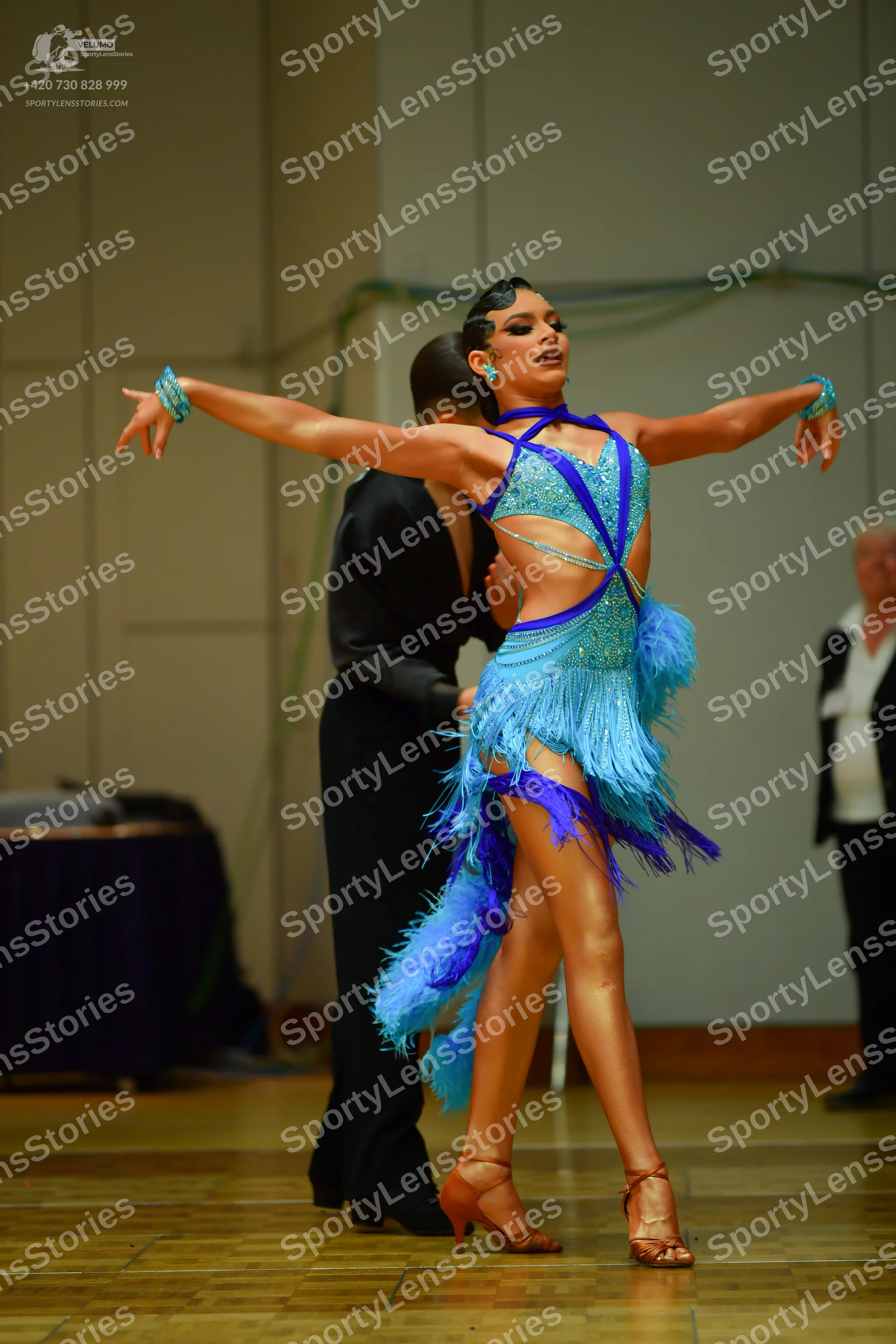 Dancesport competitor: Female dancer: light blue latin dance dress with dark blue trim, sequins, and lo