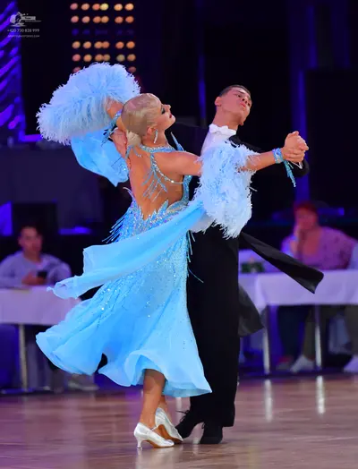 Dancesport competitor: Female dancer: light blue ballroom dress with silver sequins and large, fluffy l