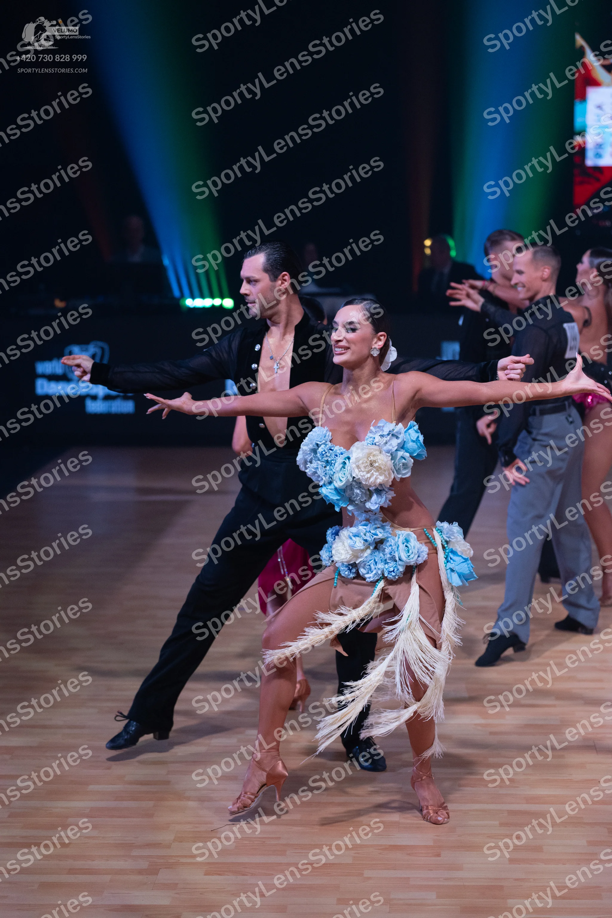 Dancesport competitor: Male dancer (foreground): black long-sleeved shirt and black trousers