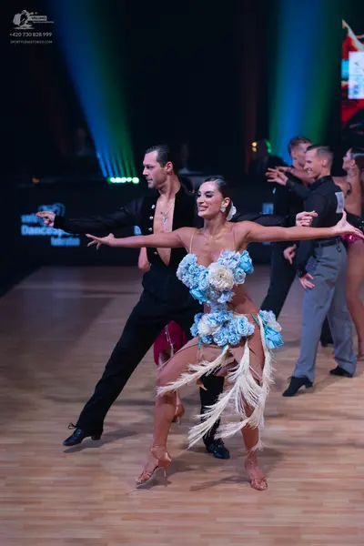 Dancesport competitor: Male dancer (foreground): black long-sleeved shirt and black trousers