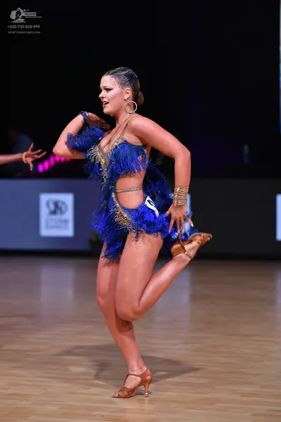 Dancesport competitor: Female dancer: cobalt blue Latin dance dress with blue fringe and gold/bronze se