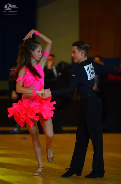 Dancesport competitor #146: Female dancer: bright pink latin dress with a ruffled skirt and matching pink wr