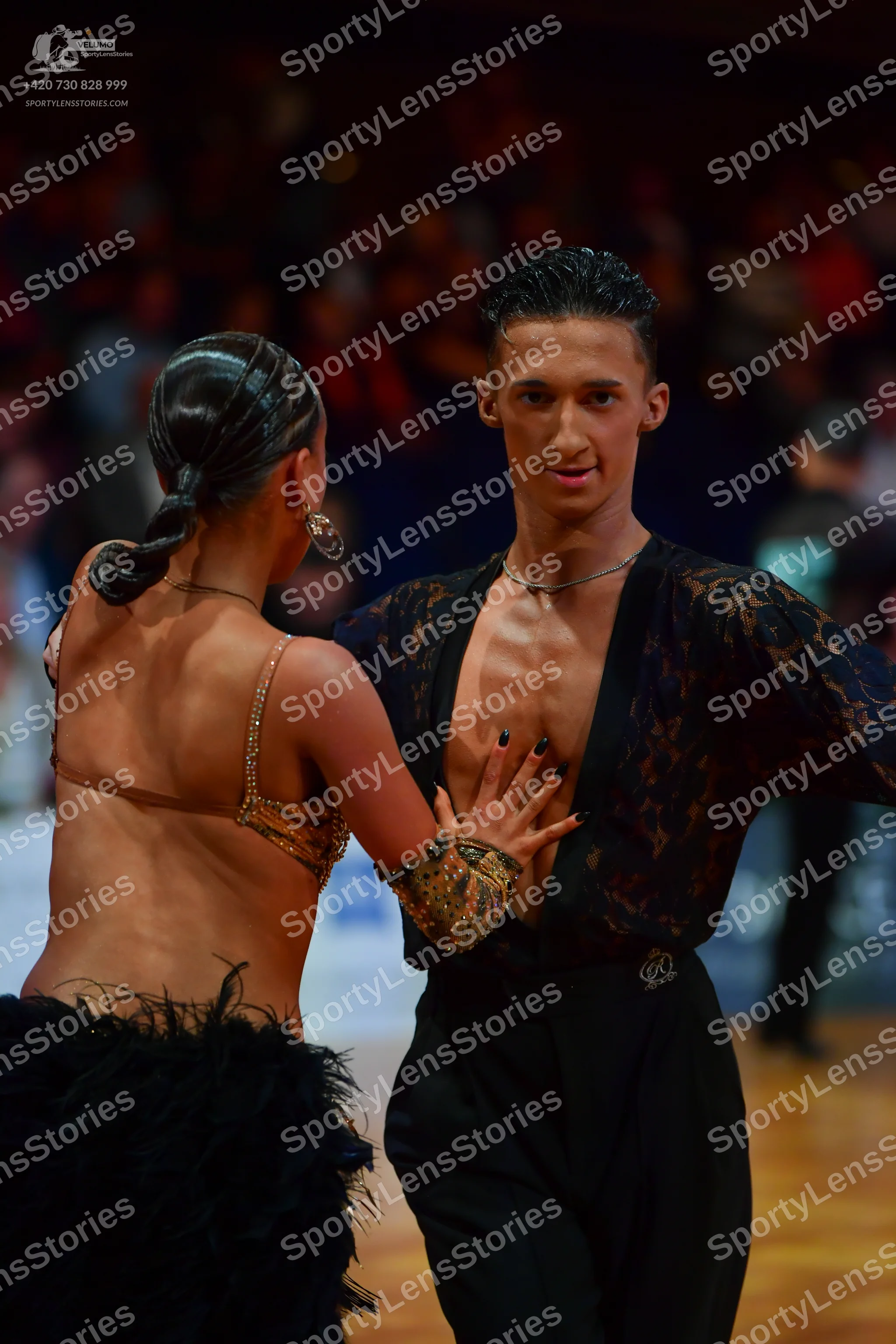 Dancesport competitor: Male dancer: black lace sheer shirt with long sleeves, black pants, and a thin s