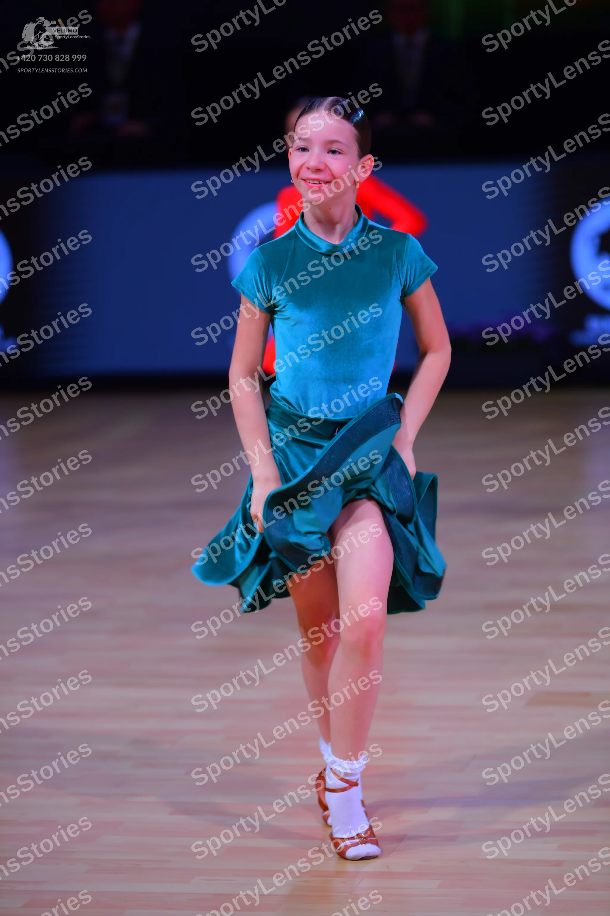 Dancesport competitor: Female dancer: teal satin-like short-sleeved dress with a high neck and a flared