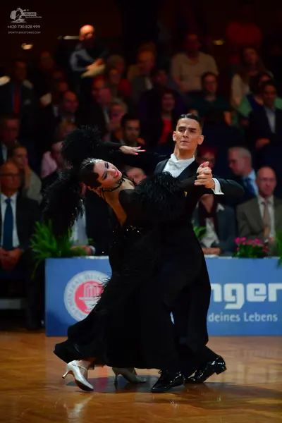 Dancesport competitor: Male dancer: black suit with a white shirt and black patent leather shoes
