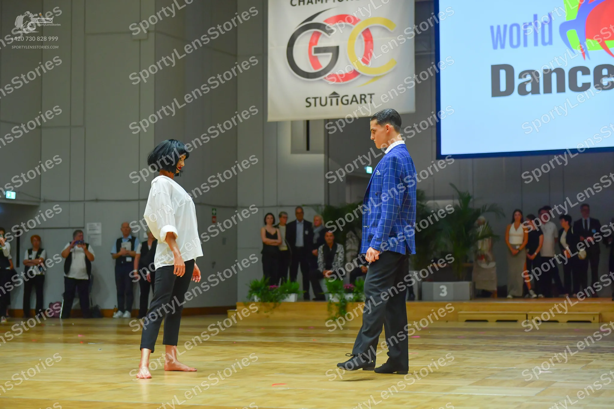 Dancesport competitor: Female dancer: white long-sleeved shirt and black pants
