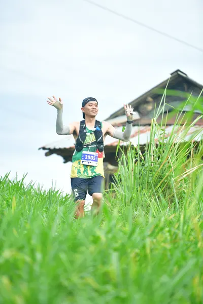 Marathon runner #3086: Runner 1: green and white patterned jersey, dark shorts, dark cap, and a white c