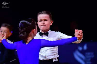 Dancesport competitor: Male dancer: white long-sleeved shirt, black bow tie, and black trousers