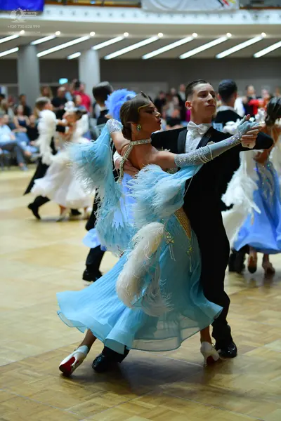 Dancesport competitor: Main female dancer: light blue ballgown with voluminous feathery sleeves and ski
