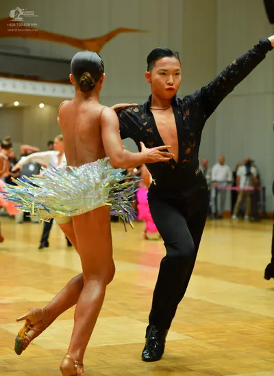 Dancesport competitor: Female dancer: skin-toned Latin dance costume with a short, multi-colored, refle