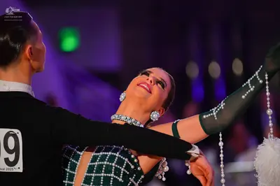 Dancesport competitor: Male dancer: black long-sleeved suit jacket with a white shirt collar visible