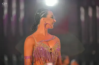Dancesport competitor: Female dancer: purple Latin dance costume decorated with sequins and long fringe